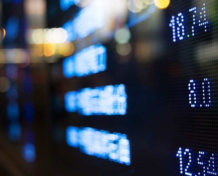 digital stock board showing green arrows