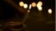 Hands holding single lit candle with dark background