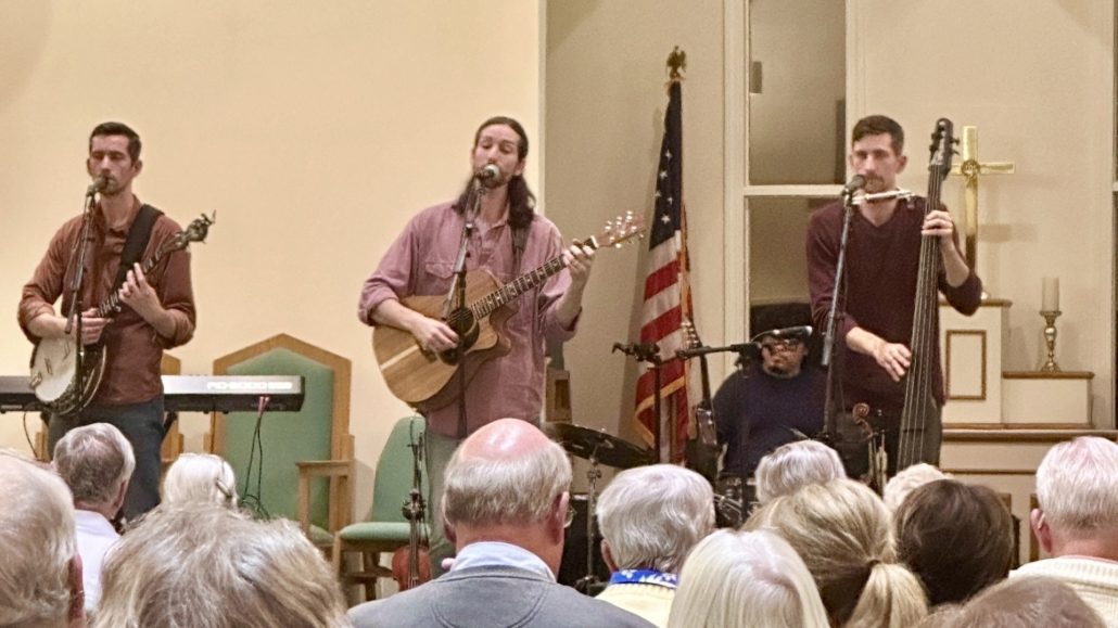 Three men playing banjo, guitar and string bass in chapel