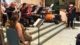 Orchestra with singer and bass guitar playing in front of chapel