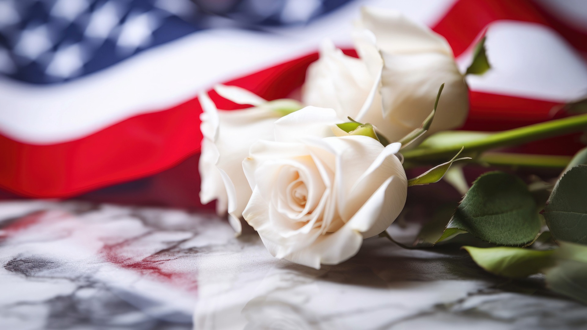White roses and American flag on marble slab