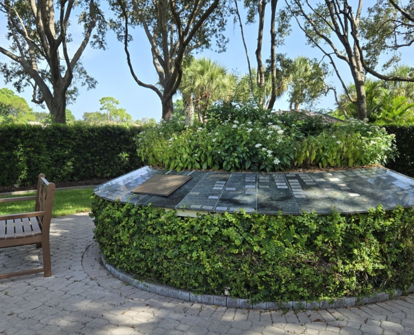 Flowers in center of Memorial garden with wooden bench