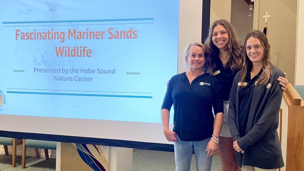 Three women standing by video screen with Mariner Sands Wildlife presentation