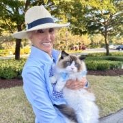 Woman wearing fedora with blue-eyed cat