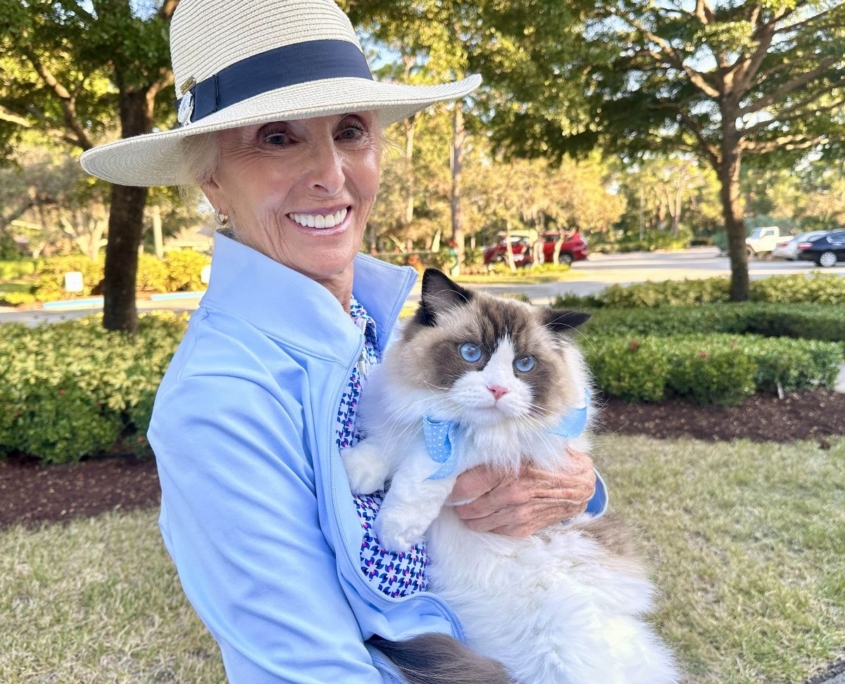 Woman wearing fedora with blue-eyed cat