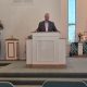 Pastor Carr stands behind new pulpit in Chapel sanctuary