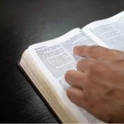 Liturgists Left forefinger on Bible page to show reading