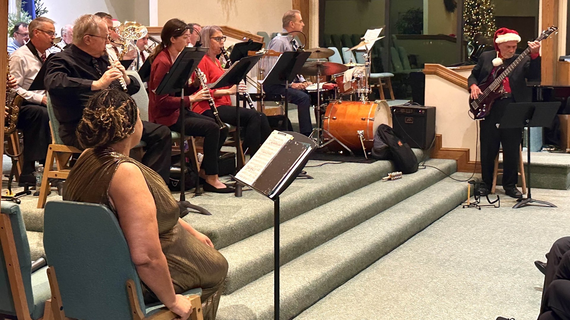 Orchestra with singer and bass guitar playing in front of chapel