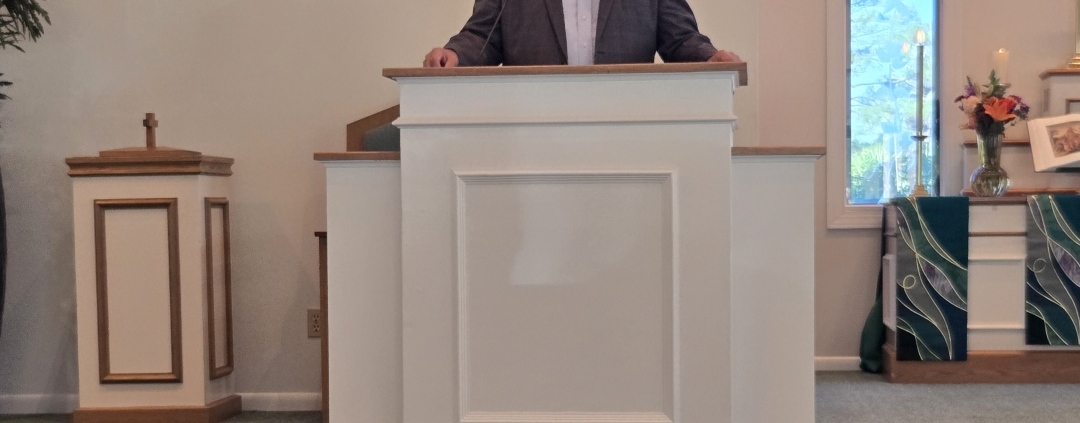 Pastor Carr stands behind new pulpit in Chapel sanctuary
